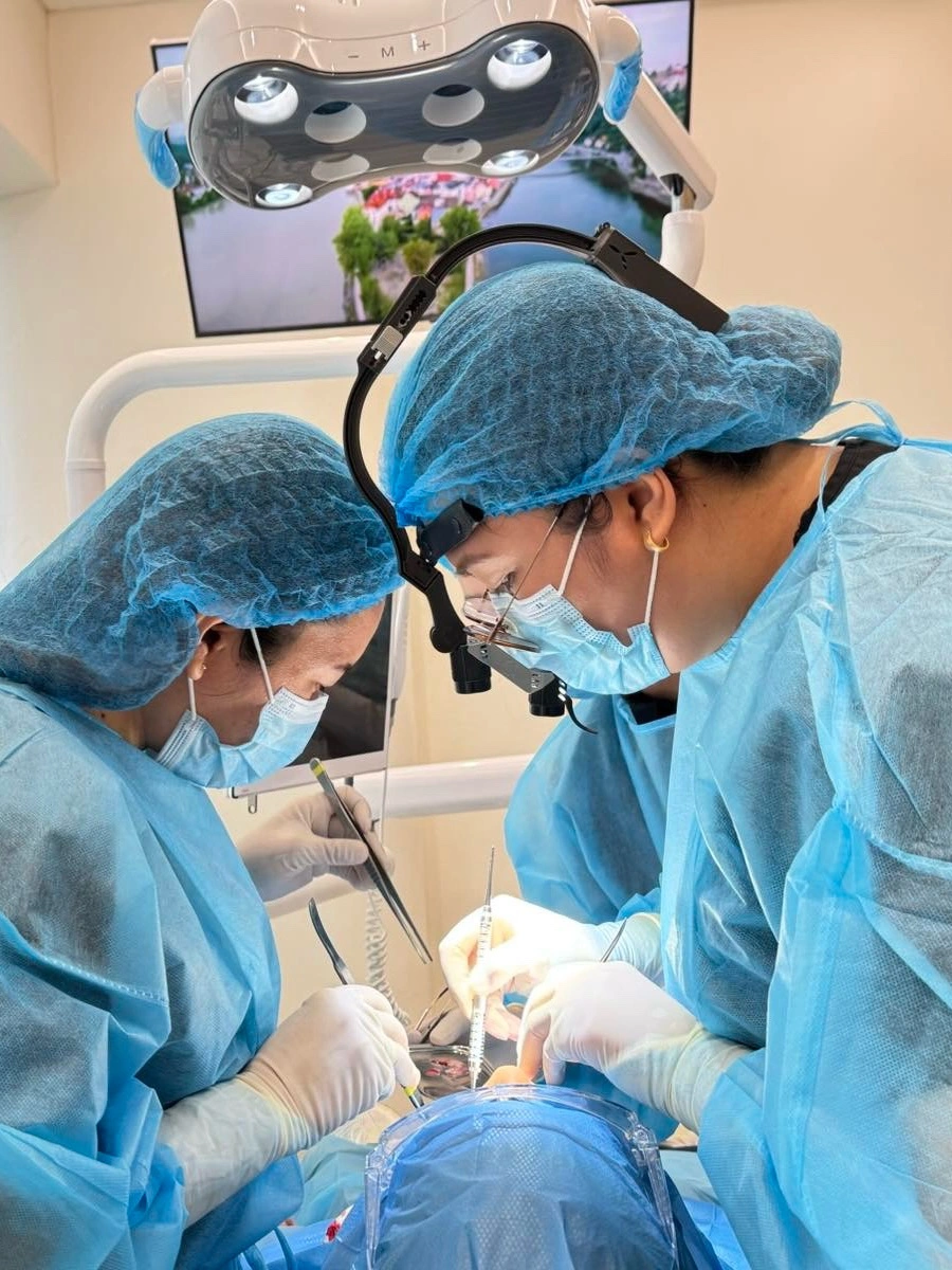 Oral surgeons in surgical gowns performing wisdom tooth extraction at Affinity Dental Clinics Alabang 