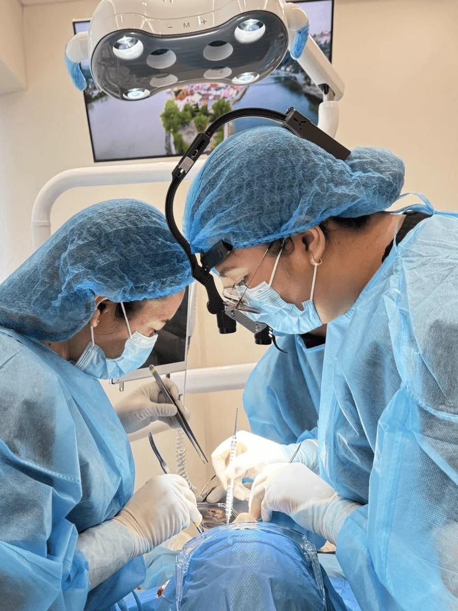 Professional dental surgeons performing a procedure at Affinity Dental Clinics Alabang with full protective gear