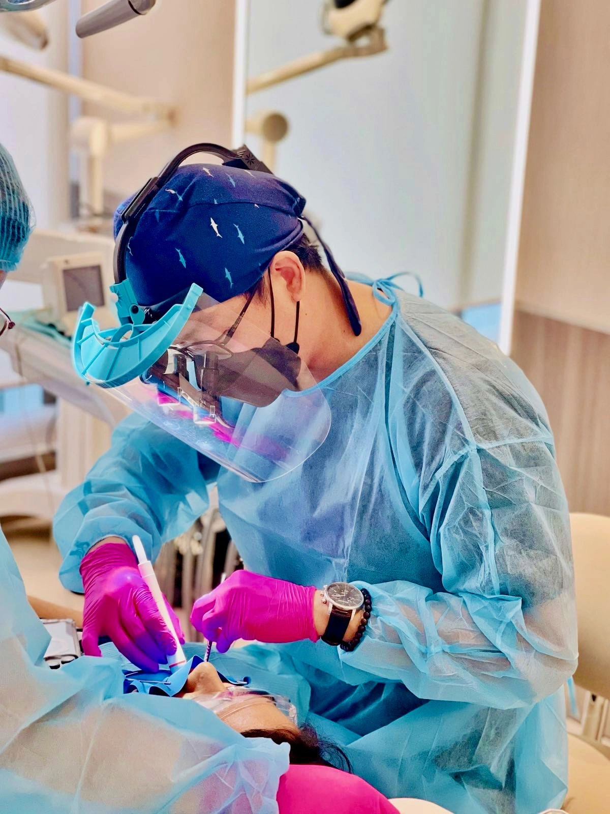 Dentist in full protective gear performing root canal treatment using modern dental technology at Affinity Dental Clinics.