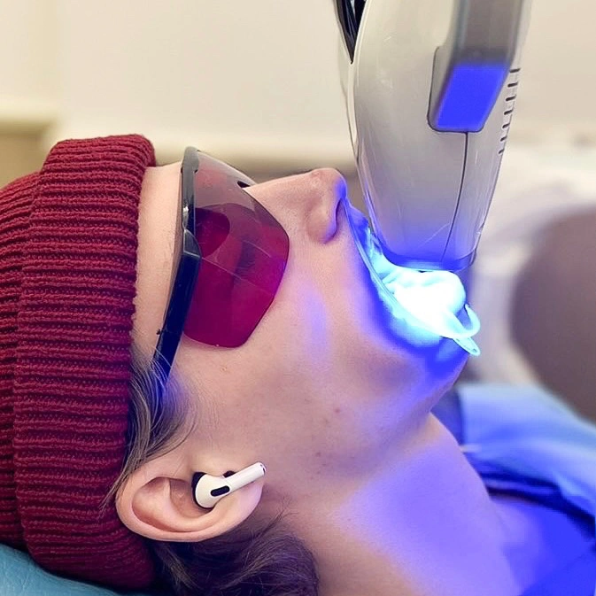 Patient undergoing professional teeth whitening with LED light at Affinity Dental Clinics.