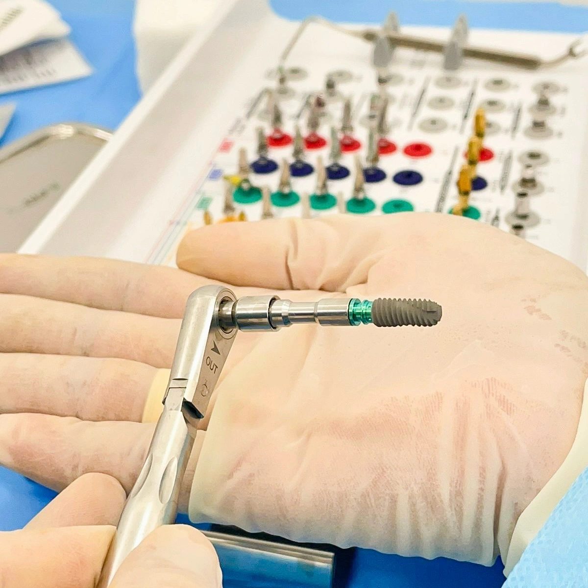 Close-up of a titanium dental implant held by a dental surgeon at Affinity Dental Clinics.