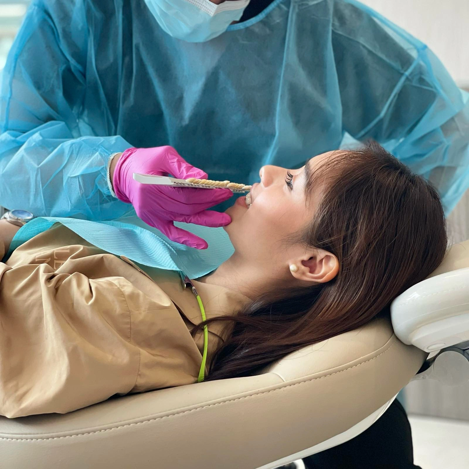 Dentist comparing a patient’s tooth color with a dental shade guide during consultation at Affinity Dental Clinics