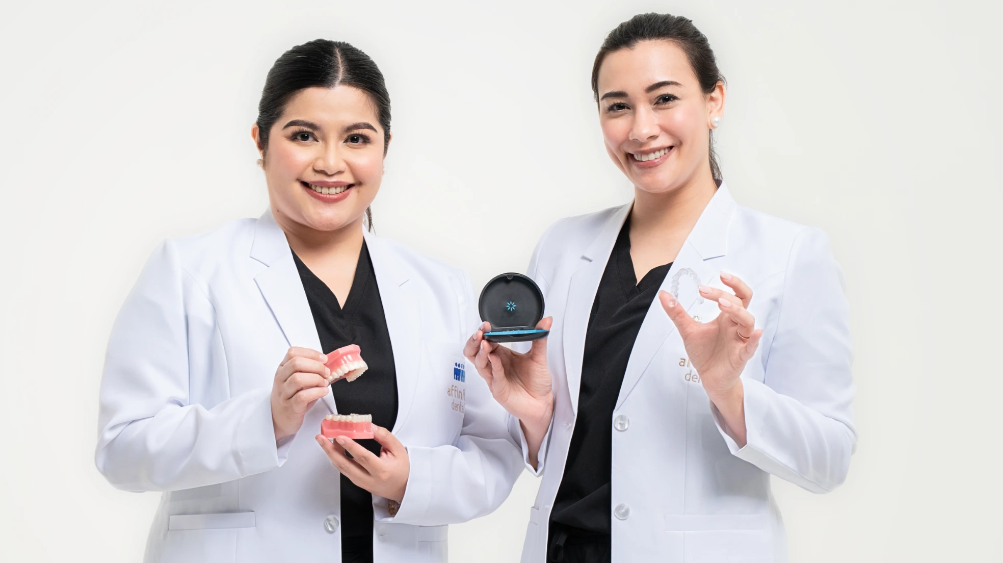 Affinity Dental Clinics dentists holding Invisalign clear aligners and dental models, highlighting their expertise in orthodontic and Invisalign treatment.