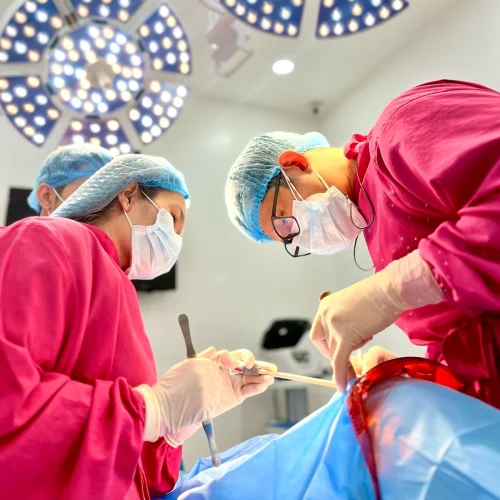 Oral surgeons performing dental implant surgery at Affinity Dental Clinics Makati operating room under surgical lights