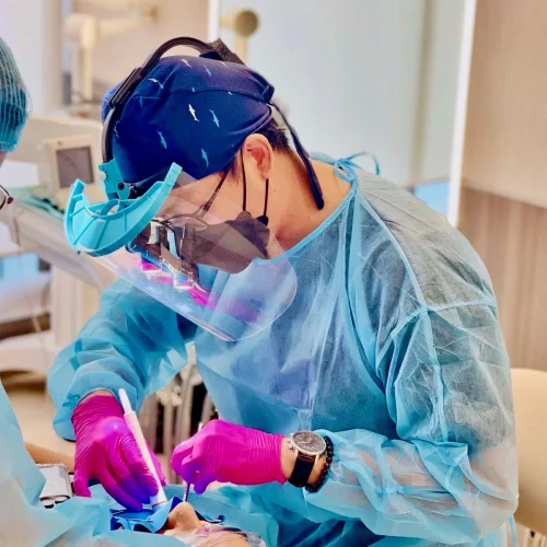 Dentist in full protective gear performing root canal treatment using modern dental technology at Affinity Dental Clinics.