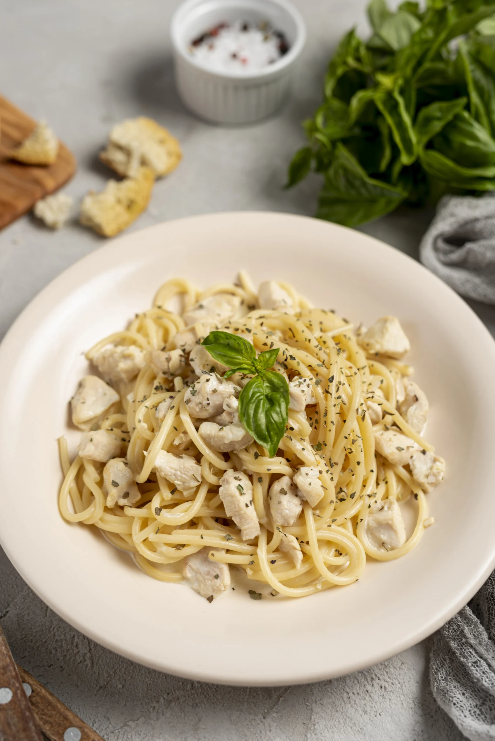 A plate of creamy white pasta with chicken and basil, representing safe, non-staining food options after teeth whitening.