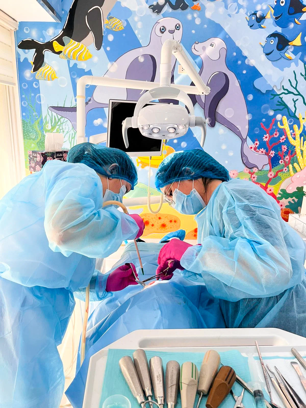 Surgeons operating in colorful pediatric surgical suite with child-friendly decorations